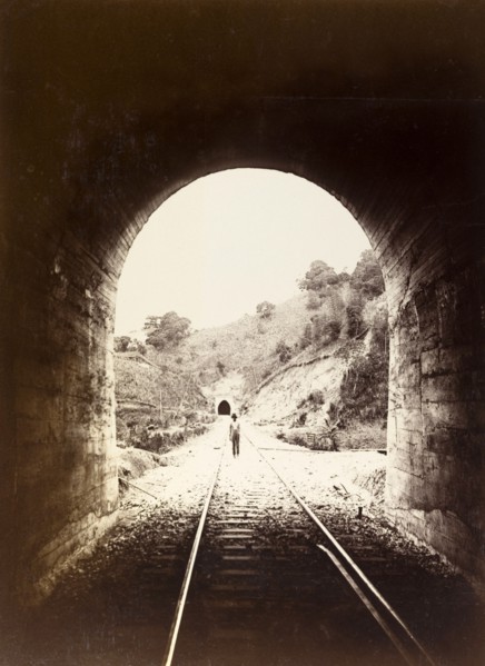 Railway tunnel, Jamaica. View from inside a railway tunnel looking out towards a man who stands on