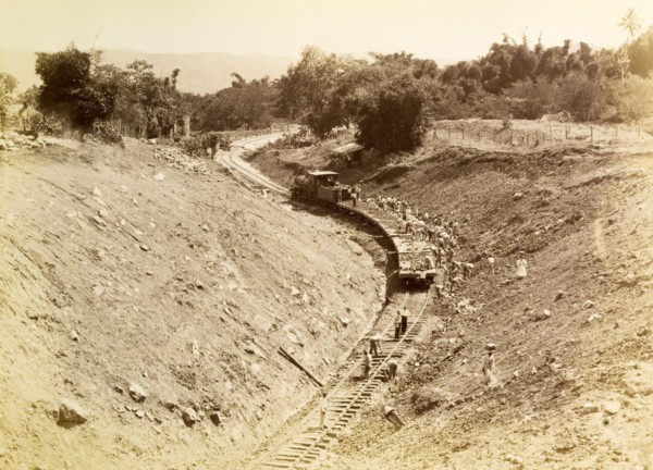 Rail track construction, Jamaica. Labourers at a railway construction site pile discarded rubble