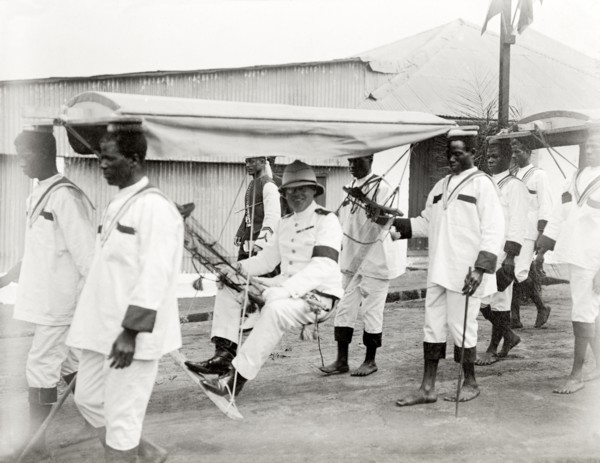 Duke of Connaught in a portable hammock. A smiling Duke of Connaught is carried along in a portable