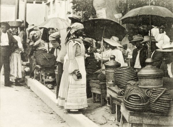 Selling jackass rope tobacco. A line of street traders sit beneath umbrellas as they sell rolls of