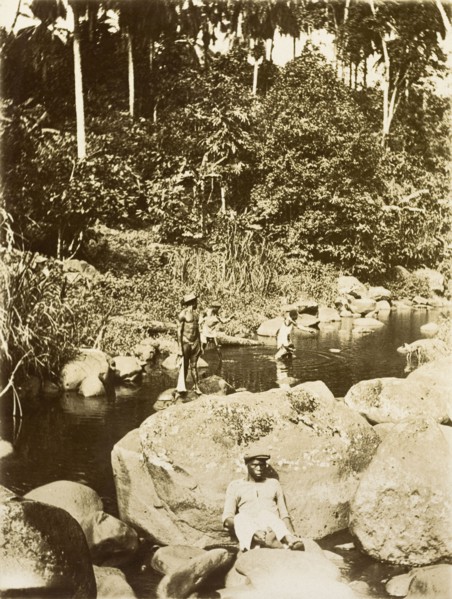 Relaxing by the river. Four men from Bioko relax by a jungle river. Bioko, Equatorial Guinea, circa