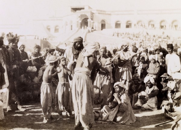 Indian musicians in Sukkur. Indian musicians with stringed instruments play to a gathered crowd,