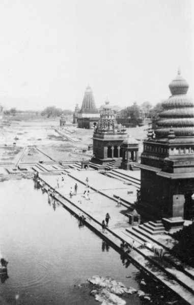 Pilgrims bathing at Wai. Religious pilgrims bathe in the shadows of ornate temples on the River