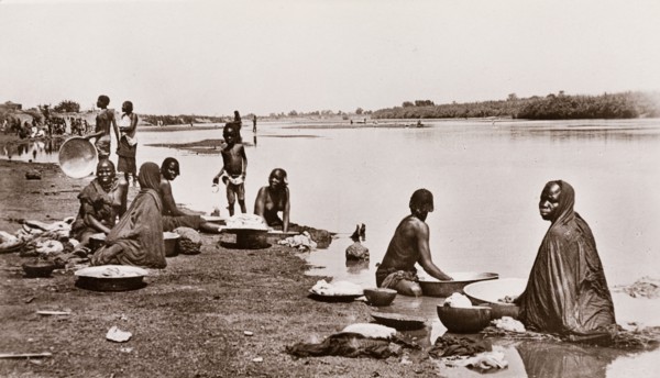Washing clothes at the river bank, Sudan. Sudanese women and children wash their clothes on the