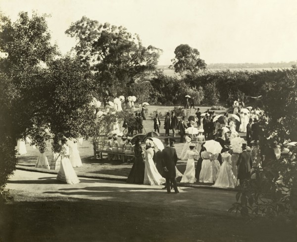 New Year's garden party at Government House, Perth. Formally dressed guests socialise in the