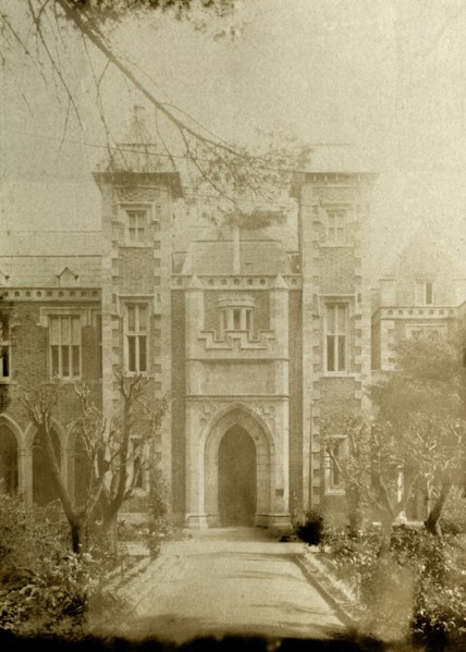 Front entrance of Government House, Perth. A wide path, flanked by trees, leads up to an arched