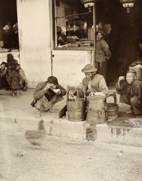 A meal by the wayside', Hong Kong. A Chinese street trader distributes food from a wooden bucket by