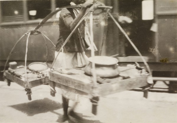 Burmese hawker at a railway station. A Burmese hawker attempts to sell his wares to passers-by at a