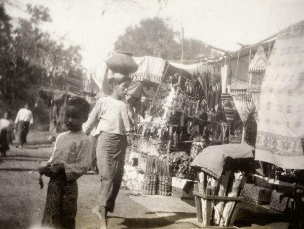 Fish festival in Shwezayan. A Burmese woman balances a ceramic pot on her head as she walks past