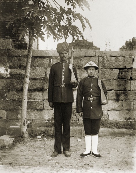 Indian and Chinese officers of the Hong Kong Police Force. Two Hong Kong police officers, one