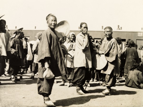 Women at a station on the Peking to Hankow railway line. Three Chinese women gaze curiously into