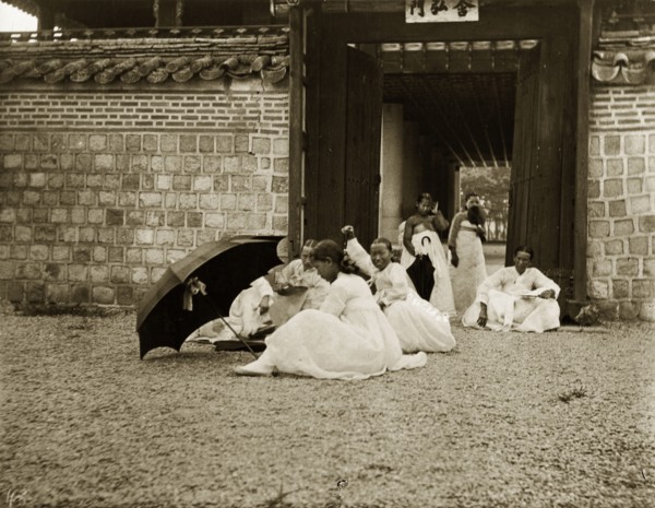 Korean women in traditional 'hanbok' dress. A group of Korean women and girls sit in the grounds of