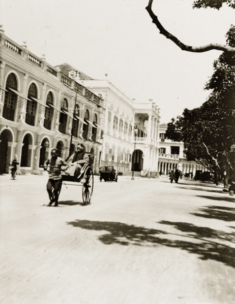 Rickshaw on the 'praya' in Macao. A rickshaw travels along the 'praya' (waterfront promenade) in