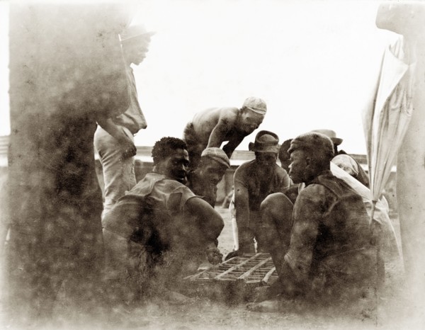 Off-duty diamond mine workers. African workers from the De Beers diamond mines sit around a small