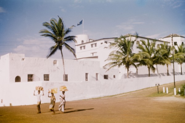 Breadsellers at Elmina Castle. Three breadsellers walk along a road adjacent to Elmina Castle.