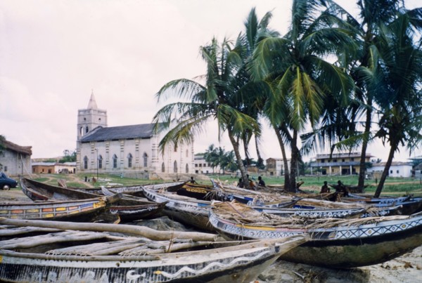 Painted fishing boats at Anomabu. A collection of painted fishing boats lie on the sand close to a