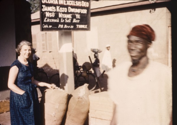 Street trader's stall in Tamale. A European woman inspects sacks at a street traders stall beneath
