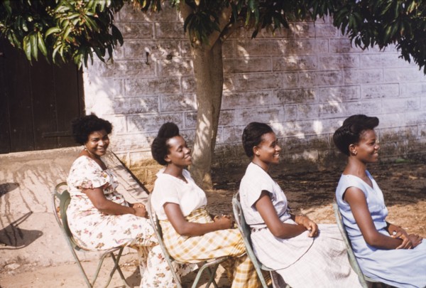 Hairstyles of four Ghanaian women. Four female Assistant Education Officers sit in a row in