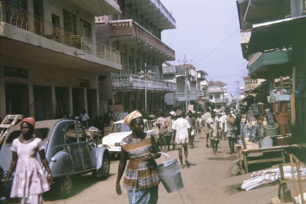 Busy urban street in Freetown. Pedestrians and road traffic crowd a busy urban street in Freetown,