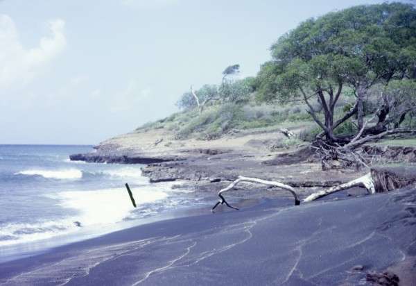 Black sand beach in Grenada. View across a beach of volcanic black sand. Grenada, circa 1975.