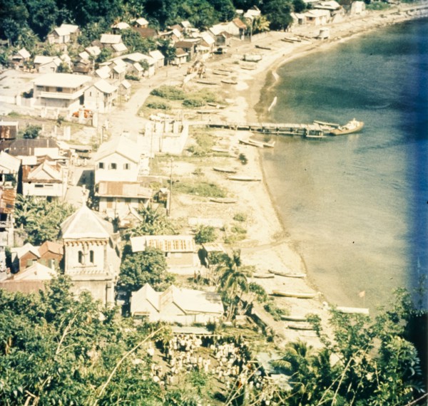 Coastal settlement in Dominica. View across a coastal settlement and beach bordering the Caribbean