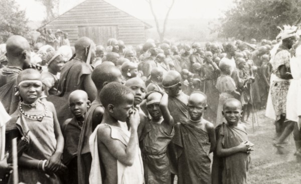 Children watching a performance, Kenya. A group of African children crowd together as they watch an