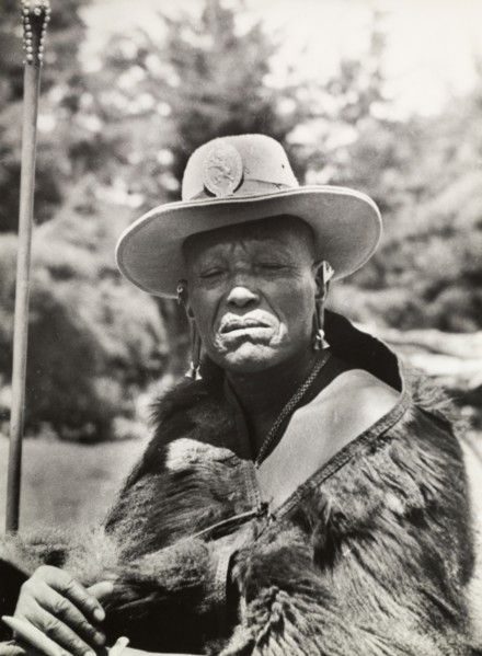 Chief Murigo. Portrait of Chief Murigo wearing traditional Kikuyu jewellery and holding a staff. He