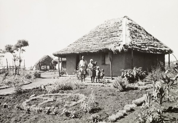 A Kikuyu family outside their home. A Kikuyu family pose in the garden outside their new,