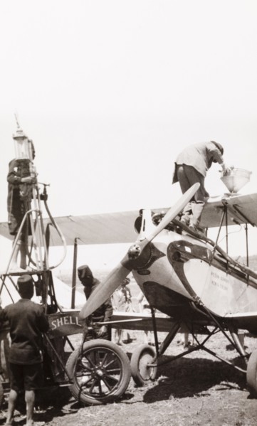 Refuelling an EAA aeroplane. Men refuel a East African Airways biplane at an airfield in Kenya.