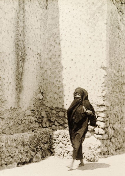 Woman in traditional Muslim dress. A woman wearing a traditional Muslim burqa walks along a street