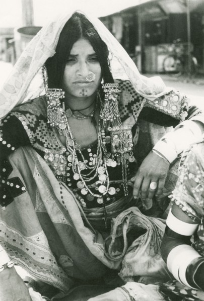 A woman wearing elaborate Indian jewellery. Seated portrait of an Indian woman, identified in an