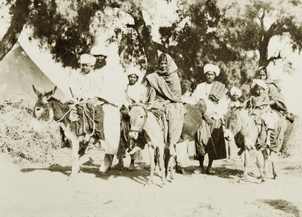 Indian family travelling by donkey. An Indian family travel along a rural road: some riding