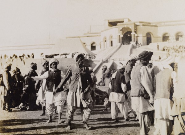 Male dancers in Sukkur. Male dancers perform to seated spectators at an outdoor event in Sukkur.