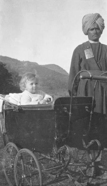 Indian servant with a British toddler. A turbaned Indian servant watches over a British toddler who