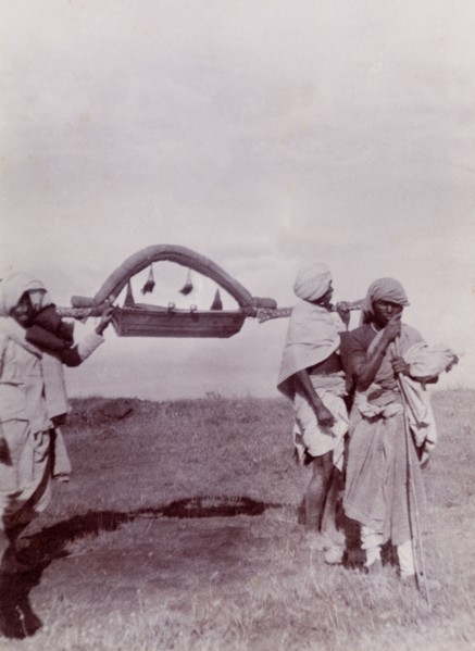 Palanquin for a baby. A group of Indian servants carry a miniature, tasselled palanquin for a baby,