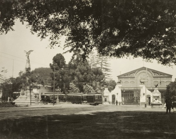 A street tram in Lima. A tram travels around the corner of a street in Lima, past a grand,