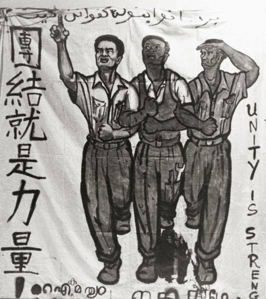 Unity is Strength'. A hand-painted banner campaigns for unity during the Singaporean Merdeka