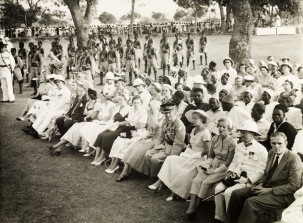Awaiting Queen Elizabeth II's arrival. A seated assembly of African and European dignitaries await