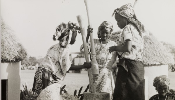 Nigerian girls using pestles and a mortar. Three young women from Kaduna Children's Village use