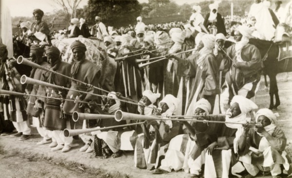 Nigerian trumpet players. A group of traditionally dressed Nigerian musicians assemble at an