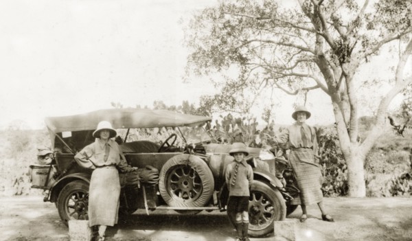 Preparing to embark on a journey. Two European women and a young boy pose beside a convertible car