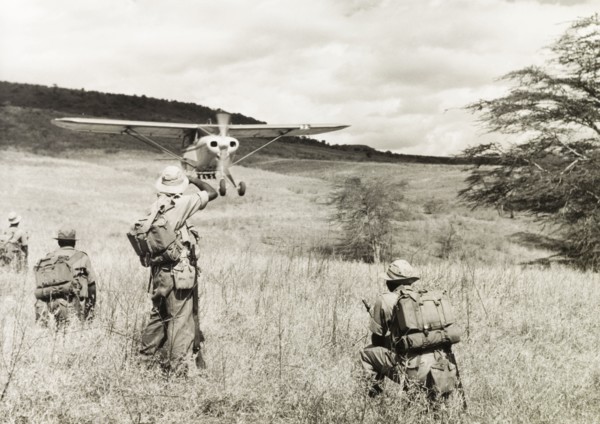 Kenya Police Airwing. Four officers of the Kenya Police Airwing watch as a light aircraft comes in