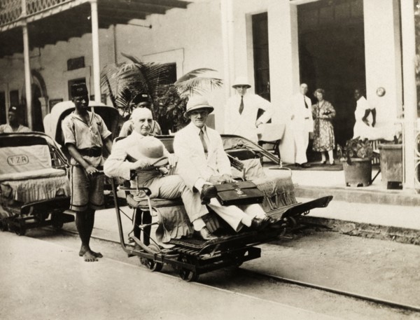 A rail trolley at Beira station. Two European men ride a narrow gauge rail trolley at Beira railway