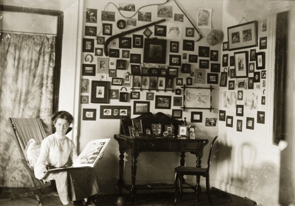In the drawing room at Penshew House. A European woman browses through a photograph album in the