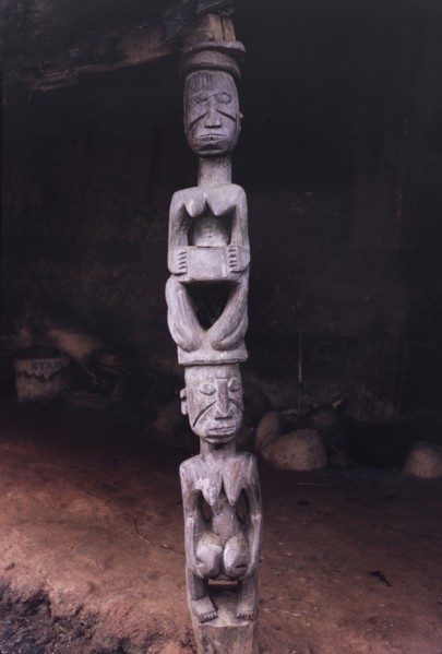 A Yoruba wood carving. A Yoruba wood carving of two women kneeling one on top of the other. In