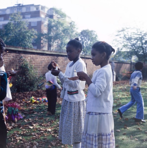 Lighting candles for Diwali. Two girls light candles outdoors to celebrate Diwali, the Hindu