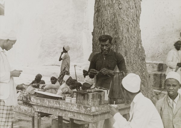 Snack food in Lamu. A street trader grills snack food in Lamu's main square. Lamu, Kenya, circa