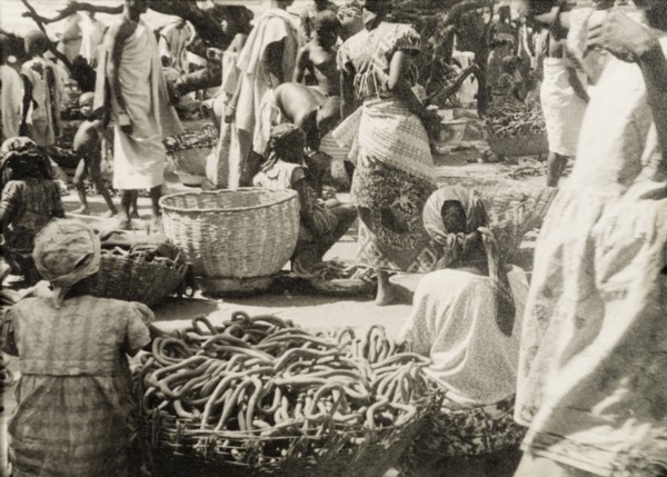 Pretzel stalls at a Ghanaian market. Female traders sell baskets full of pretzels at a busy market