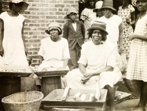 Fish stall in St Lucia. A female trader sits smoking a pipe at her street stall, where she sells