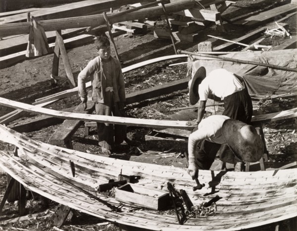 Constructing a sampan. Two men build a sampan at a boatyard in Aberdeen Harbour, whilst a third